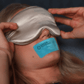 woman with silver sleep mask and blue mouth tape